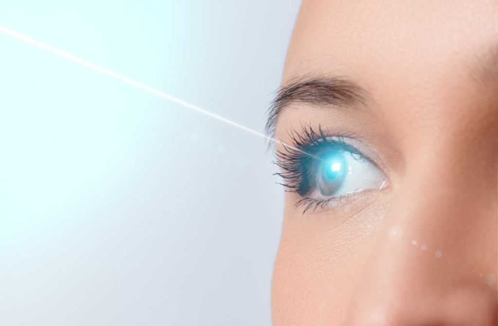 Up close image of a woman's eye emitting a laser beam.