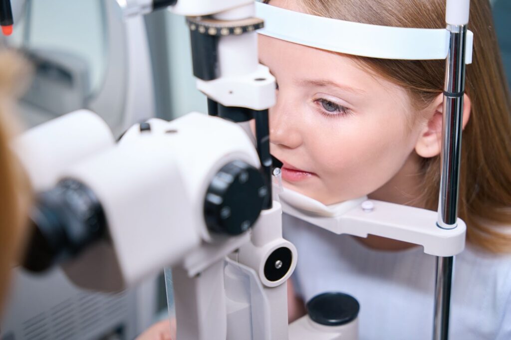 A child is getting an eye exam administered by a healthcare professional.