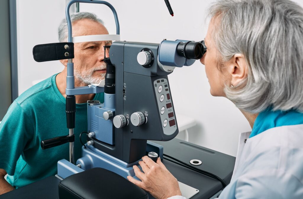 An optometrist examining a patient's eyes during an eye exam checking for signs of age-related macular degeneration.