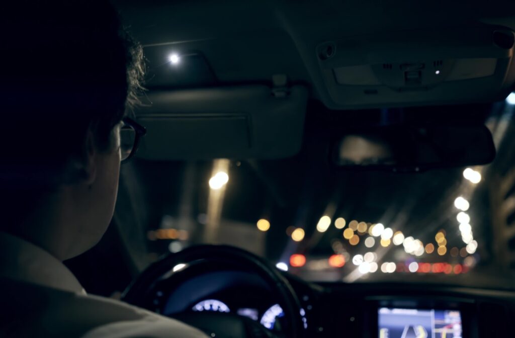 An image looking through a windshield at night that demonstrates how all the lights can cause glare while driving.
