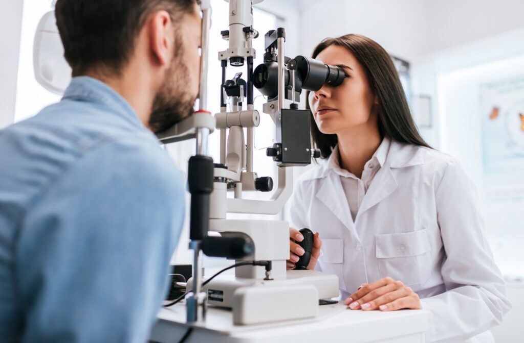 An optometrist evaluates a patient's eye with a slit lamp.