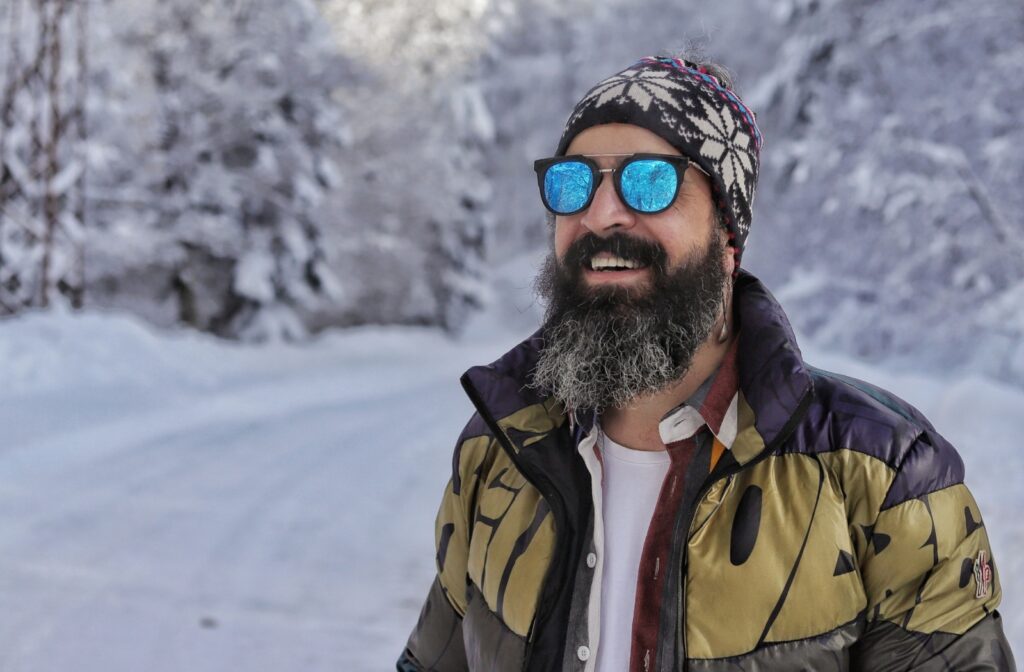A person outside in the snow wearing prescription sunglasses to help them see clearly and protect their vision.