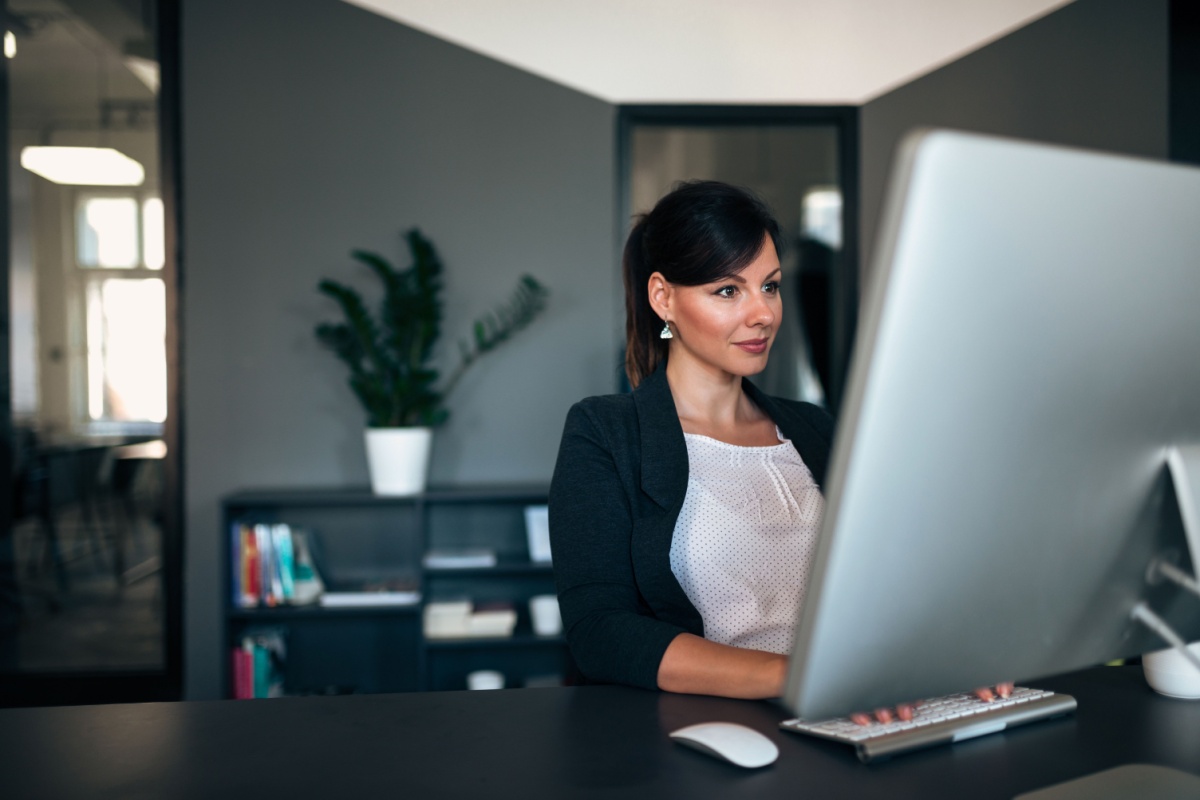 Woman working on a desktop computer.